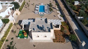 An aerial view of a hotel with a swimming pool, outdoor seating, and a landscaped garden. - Villa Tina Maria by Perle di Puglia (San Pietro in Bevagna)