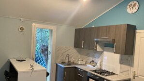 A compact kitchen with dark wood cabinets, a white countertop, and a gas stove. - Charming countryside home with a private garden (Le Beausset)