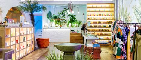 A modern interior with a central water feature, shelves with products, and a clothing rack.