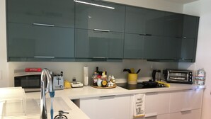 Eine moderne Küche mit Mikrowelle, Toaster und einer Wasserflasche auf der Arbeitsfläche.
