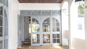 A set of white doors with glass panels and decorative metalwork, leading to an interior space. - High Life Villa (Negril)