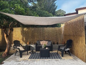 An outdoor patio with a sofa, two chairs, a small table, and a decorative plant. - Apartment in house (Saint Aygulf)
