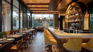 Un restaurant doté d’un long bar, d’un plafond en bois et de grandes fenêtres.