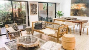 Una sala de estar moderna con sofá, sillas, una mesa de centro y un comedor.