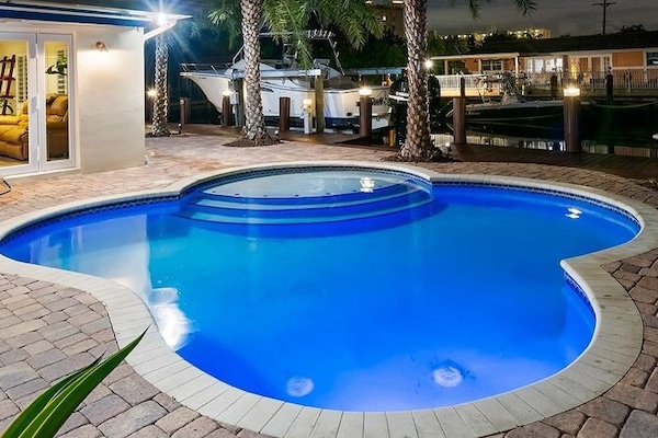 Relax in the private backyard, with amazing waterway views day & night and amenities that include a heated pool, large tiki hut with dining table and outdoor TV, 2 kayaks, BBQ grill,  comfortable lounge & dining seating all surrounded by tropical landscaping and canal views.