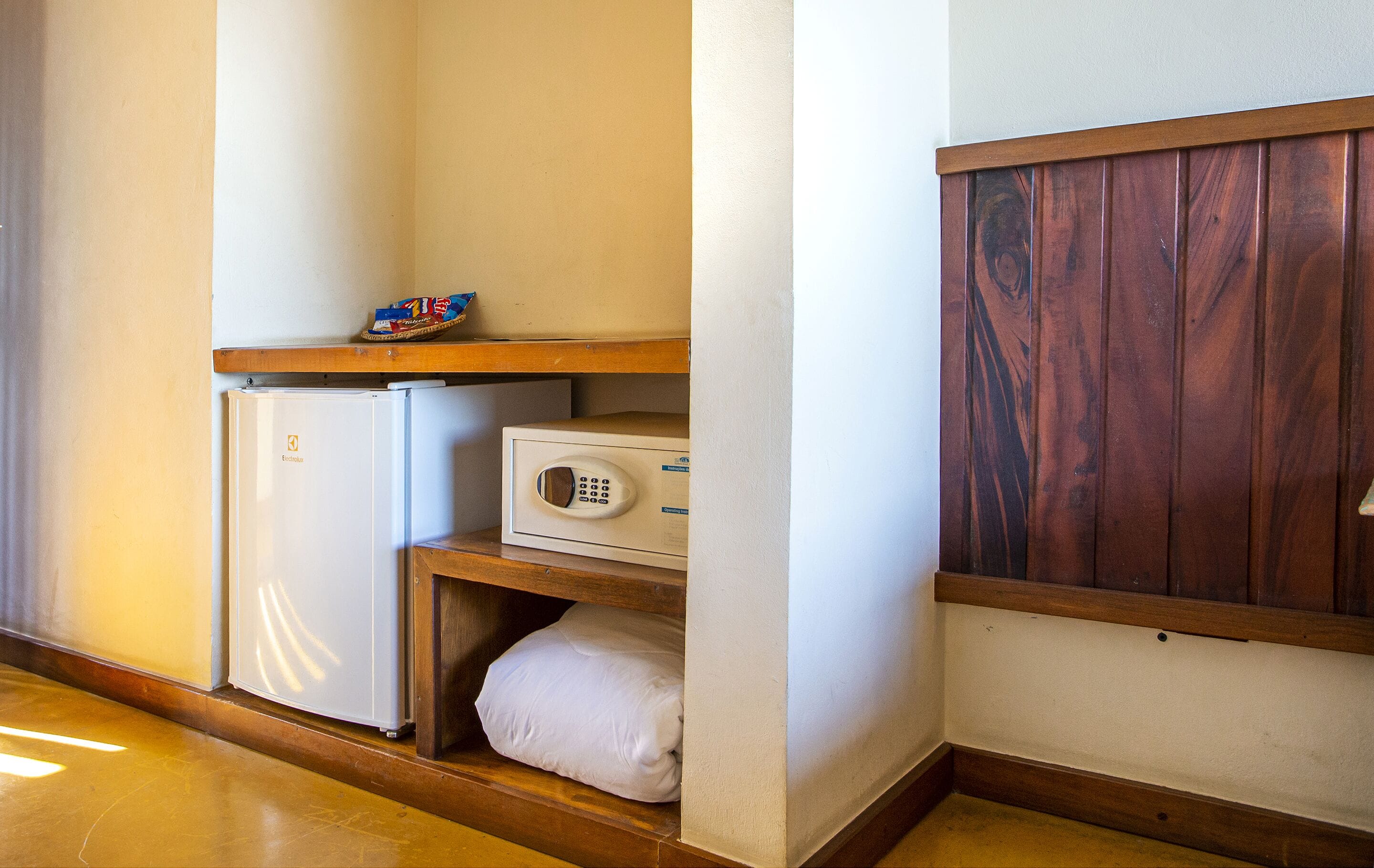 Una cocina compacta con refrigerador, microondas y encimera de madera.