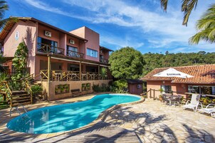 Un resort con piscina, mobiliario exterior y un edificio con balcones.