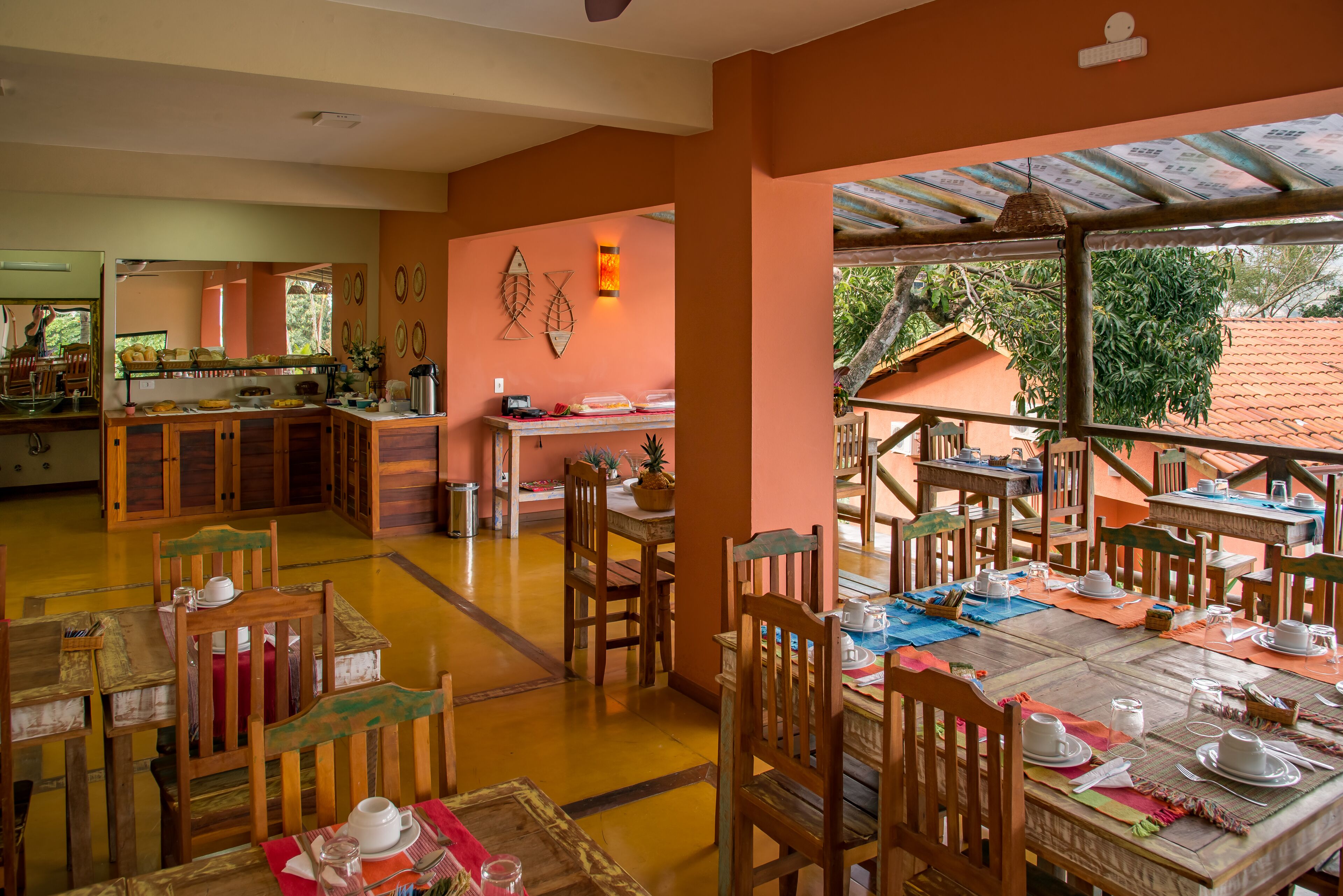 A dining area with wooden tables and chairs, a buffet counter, and a view of the outdoors.