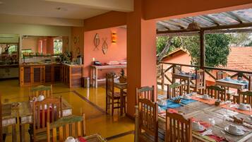 A dining area with wooden tables and chairs, a buffet counter, and a view of the outdoors.