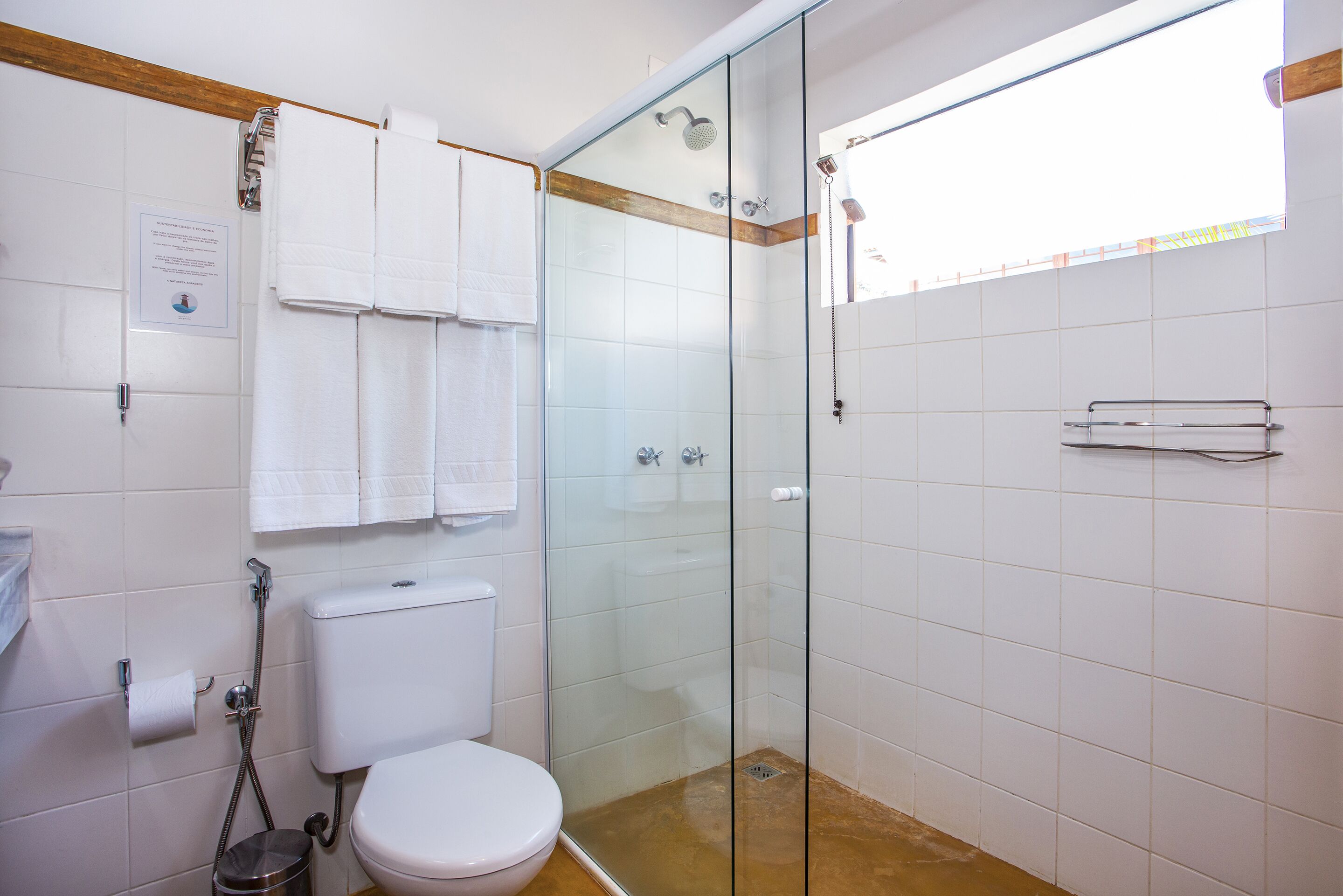 Un bagno con doccia vetro, un water e un porta asciugamani.