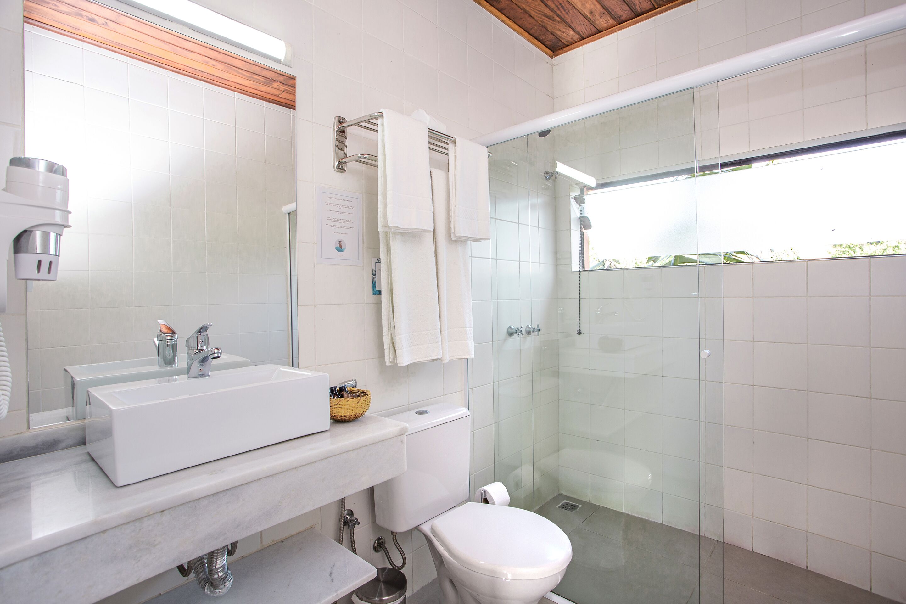 Une salle de bain moderne avec un lavabo blanc, un miroir et des toilettes.