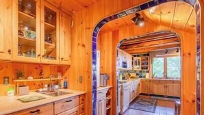 A wooden cabin interior with a kitchen area, including cabinets, a sink, and a window. - Dragonwood Retreat for Family and Friends (Parkman)