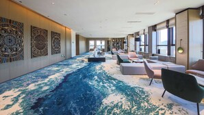 A spacious lobby with a blue carpet, modern seating, and decorative wall panels. - Howard Johnson By Wyndham Longxiang Hotel Ningbo (Ningbo)