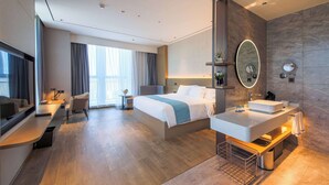 A modern hotel room with a large bed, a desk, a bathroom with a large mirror, and a view of the city. - Howard Johnson By Wyndham Longxiang Hotel Ningbo (Ningbo)