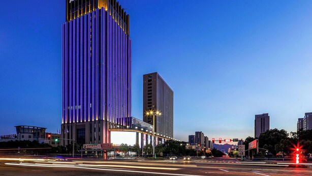 A tall building with a prominent sign at the top. - Howard Johnson By Wyndham Longxiang Hotel Ningbo (Ningbo)