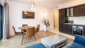 A modern kitchen with dark cabinets, a built-in oven, and a coffee machine.