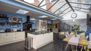 A modern kitchen with a central island, white cabinetry, and a skylight above.