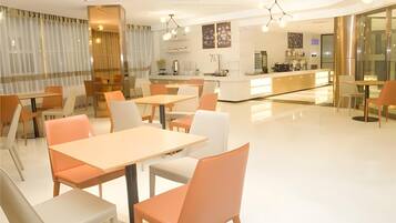 A modern restaurant with a bar area, tables, and chairs.