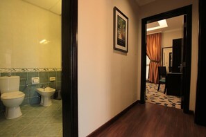 Une salle de bain d’hôtel équipée de toilettes, d’un bidet et d’un porte-serviettes.