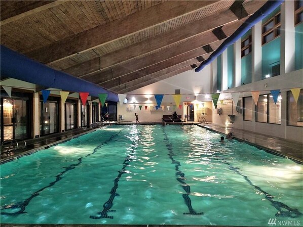 Swimmers can enjoy a leisurely lap in the pool surrounded by natural light and exposed beams.