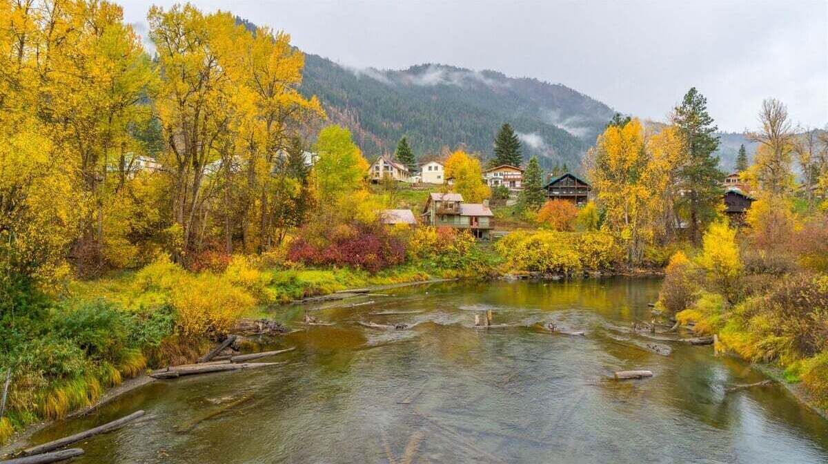 Um rio serpenteando por uma aldeia com casas às margens.