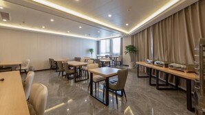 A modern hotel room with a marble floor, multiple dining tables, and chairs. There are potted plants and a large window with curtains. - Greentree Inn Zhejiang Jiaxing Honghe Town Business Hotel (Jiaxing)