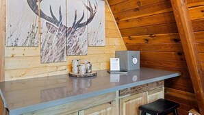 A wooden interior with a wooden ceiling, a counter with a laptop, and a deer painting. - Pet-friendly A-Frame Near Plain & Leavenworth (Leavenworth)