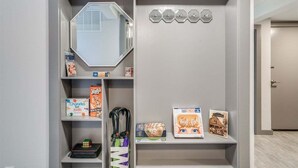 A room with a mirrored closet door, a shelf with books and a Rubik's cube, and a wall-mounted air conditioning unit. - Downtown Leavenworth 2BR – Walk to Shops & Events (Leavenworth)