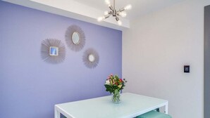 A dining area with a white table, green chairs, and a vase of flowers. - Downtown Leavenworth 2BR – Walk to Shops & Events (Leavenworth)