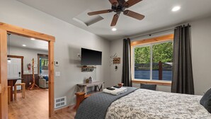 A bedroom with a bed, a TV, a desk, a chair, and a window with curtains. - Cozy Mountain Retreat Near Leavenworth w/ Private Patio + BBQ (Leavenworth)