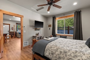 A bedroom with a bed, a TV, a desk, a chair, and a window with curtains. - Cozy Mountain Retreat Near Leavenworth w/ Private Patio (Leavenworth)