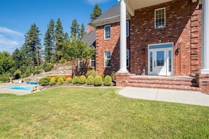 A brick house with a front porch, a swimming pool, and a well-maintained lawn. - Heavenly Heights - Sweeping Territorial Views (Leavenworth)