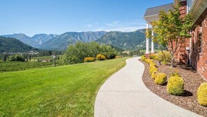 Un sentier menant à un bâtiment avec une montagne en arrière-plan.
