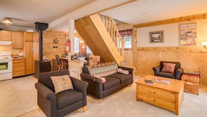 A cozy interior with a wooden staircase, a kitchen area, and a living room with a sofa and coffee table. - Cozy 2BR cabin in Plain/Lake Wenatchee with fireplace, AC, and parking. Pet-friendly (Leavenworth)