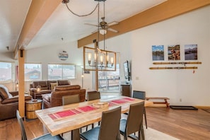 A dining area with a wooden table, chairs, and a ceiling fan. - Downtown Leavenworth Condo: 2BR + Balcony & Village Views (Leavenworth)