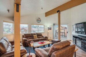 A living room with leather furniture, a fireplace, and a large window.