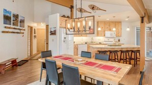 Una cucina moderna con mobili in legno, un'isola centrale e luci a sospensione.