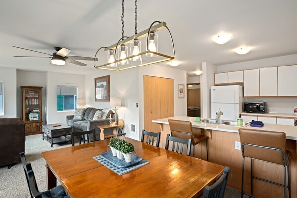Enjoy meals in the central dining area with a wooden table and chairs.