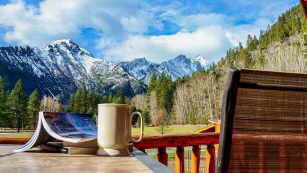 A table with a book and a mug, overlooking a mountainous landscape. - Leavenworth Views! Peaceful 2BR Lookout Suite (Leavenworth)