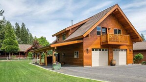 A two-story wooden cabin with a balcony, a covered porch, and a garage. - Leavenworth Views! Peaceful 2BR Lookout Suite (Leavenworth)