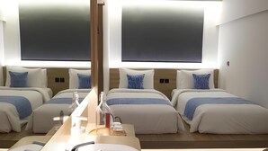 A modern hotel room with a large bed, a bedside table, a sink, and a mirror. - Qubika Boutique Hotel (Gading Serpong)