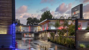 A modern hotel with a spacious courtyard, a sign for 'The Catalina Hotel', and a well-lit entrance. - The Catrina Hotel (San Mateo)