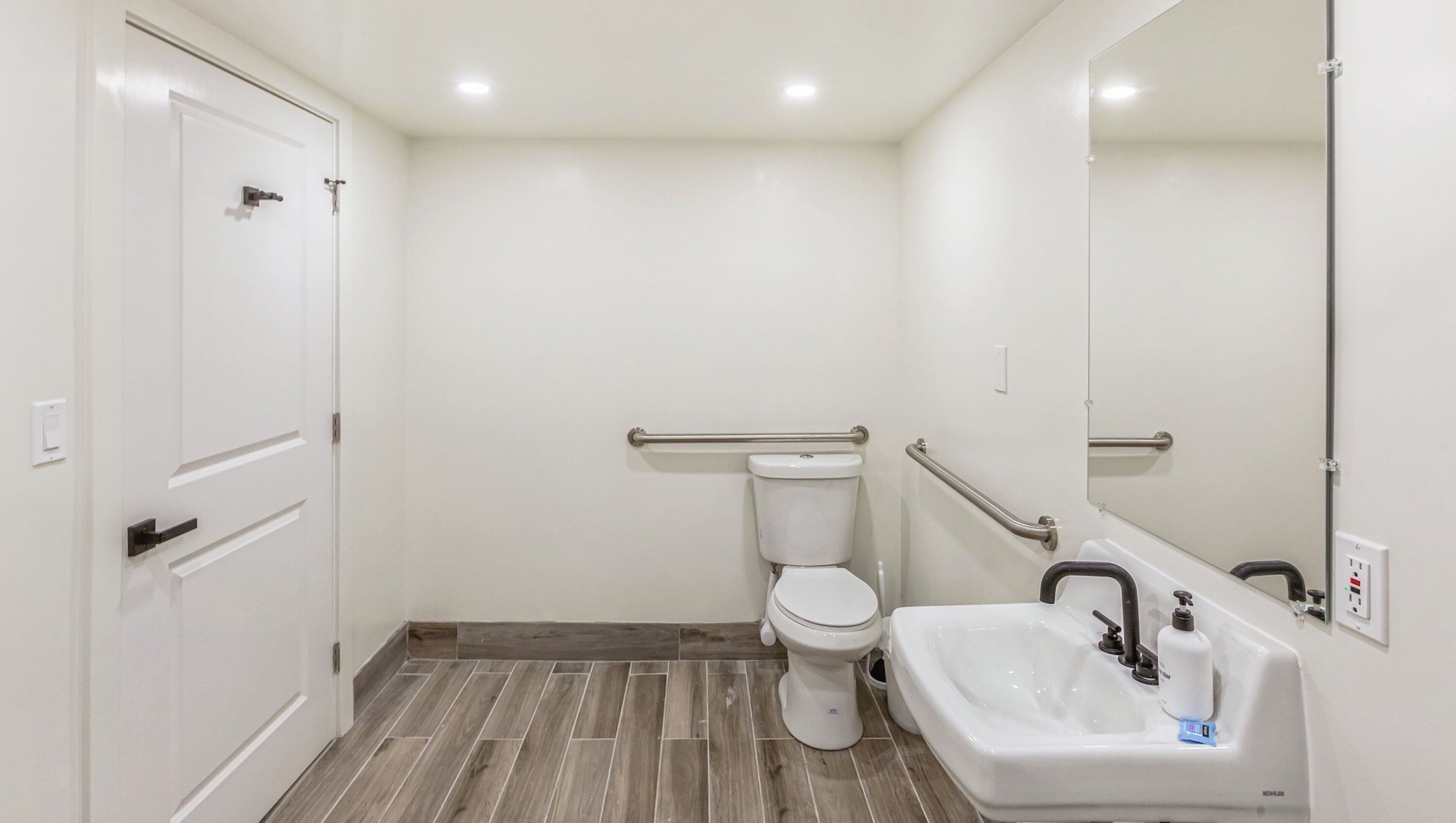 Un baño con inodoro, lavamanos y espejo.
