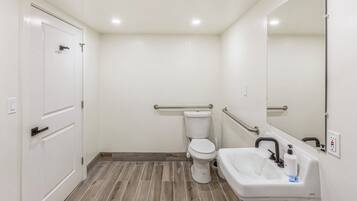 Un baño con inodoro, lavamanos y espejo.