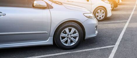 Ein Parkplatz mit mehreren in Reihe parkenden Autos.