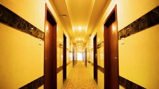 A long, narrow hotel corridor with marble-topped doors and a patterned carpet. - Greentree Inn Shanghai Baoshan District Gongfu New Village Metro Station Express Hotel (Shanghai)