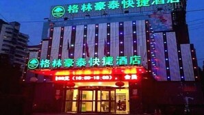 A hotel with a neon sign indicating it is a 'Quick Hotel'. - Greentree Inn Shanghai Baoshan District Gongfu New Village Metro Station Express Hotel (Shanghai)