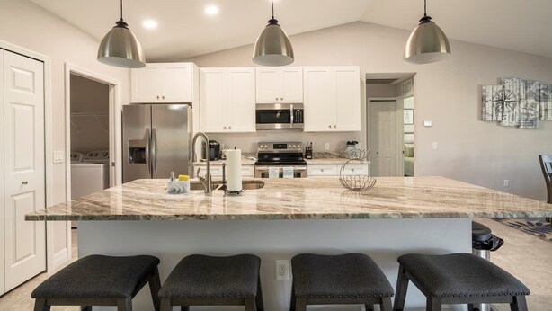 A modern kitchen with a large island, stainless steel appliances, and pendant lighting. - Luxury Cape Coral Retreat Pool, Hot Tub, Beautiful Outdoor Oasis & Pet Friendly (Cape Coral)