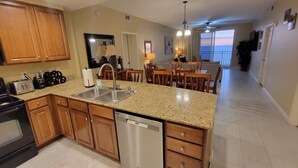 A modern kitchen with granite countertops, wooden cabinets, and a dishwasher.