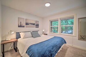 A bedroom with a bed, a nightstand, a desk, and a window with a view of trees. - Peaceful Forest Retreat by Mt. Baker Slopes! (Deming)